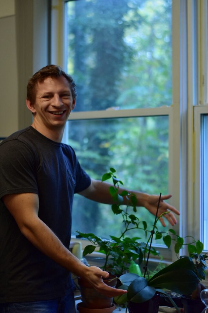 A self portrait in which I "hover hand" slash hug a pepper plant named Frank. RIP Frank 2018-2023.